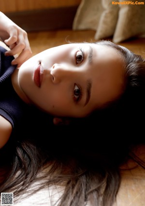 A woman in a white bra and panties sitting on a couch.