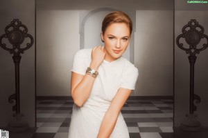 A woman in a pink dress posing for a picture.