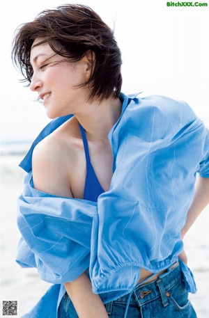 A woman in a blue dress posing for a magazine.