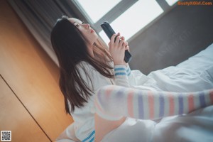 A woman laying on a bed with her legs crossed.