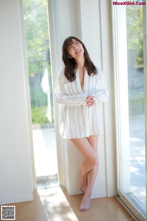 A woman in a white lingerie sitting on the floor.