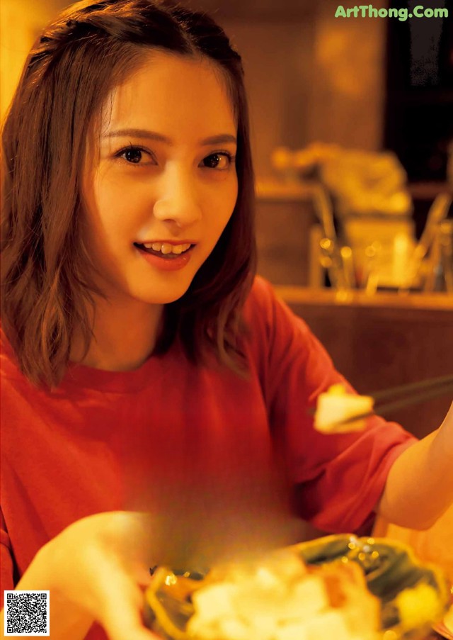 A woman sitting at a table with a plate of food.