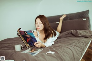 A woman sitting on the stairs reading a magazine.