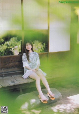 A woman in a red dress sitting on the ground.