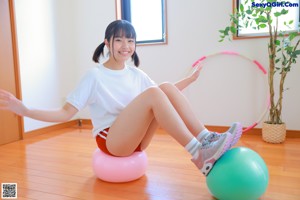 A woman sitting on a ball in a room.