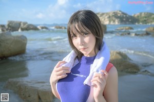 A woman in a bathing suit sitting on the beach.