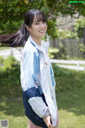 A woman holding up a white shirt over her head.