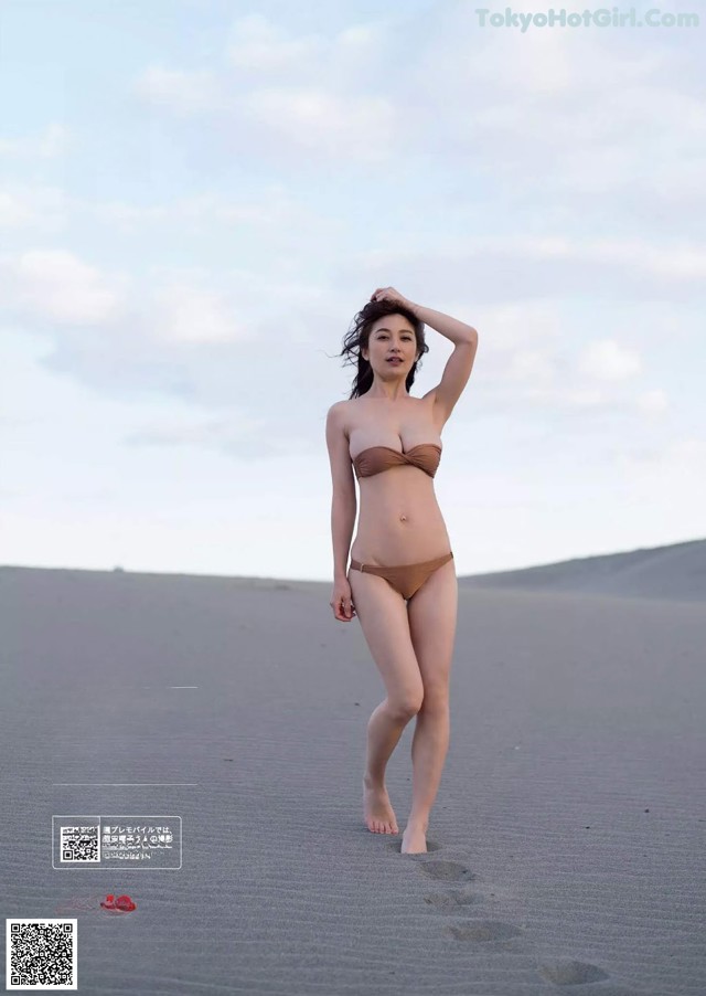 A woman in a bikini standing on a beach.