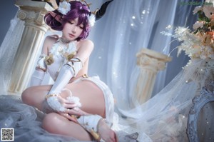 A woman in a white dress with purple hair and horns.