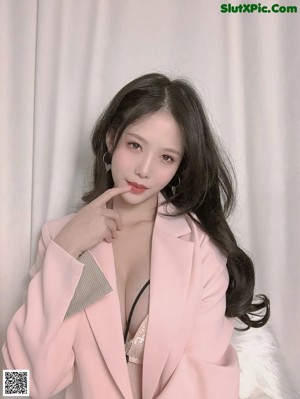 A woman in a pink robe posing for a picture.