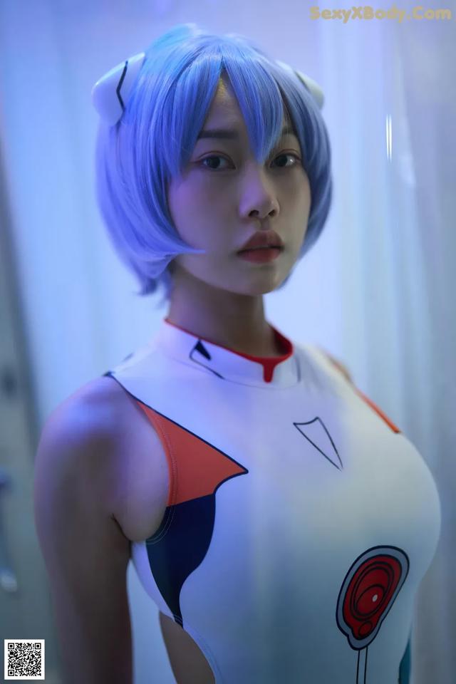 A woman with blue hair wearing a white and red outfit.