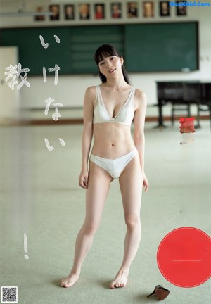 A woman in a blue swimsuit sitting on the ground.