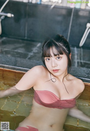 A woman sitting on a tatami mat in front of a window.