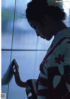 A woman in a colorful kimono posing for a picture.