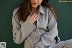 A woman in a white blouse and black skirt posing for a picture.