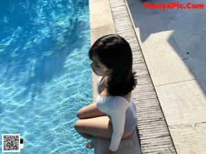 A woman in a blue and white bathing suit standing in front of a mirror.