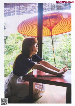 A woman in a white jacket and skirt posing for a picture.