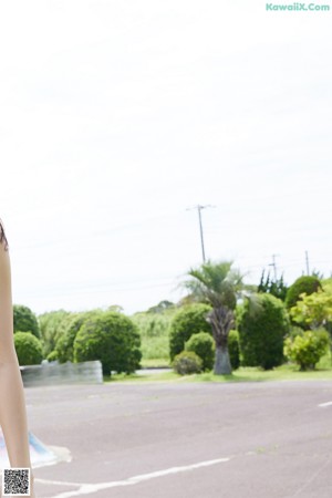 A woman in a blue and white floral dress on the beach.